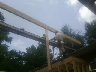 Carpenter setting a ridge beam over a new addition frame — Ice Dam Removal by Roofing Brothers in Sutton